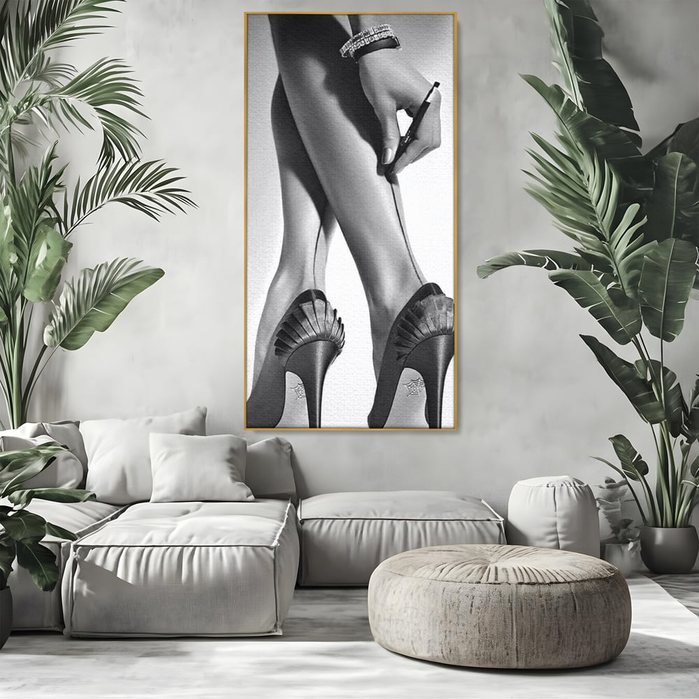 Tablou canvas cu tablou alb-negru picioare dama si pantofi cu toc, in rama de aluminiu auriu, pe perete intr-un living
